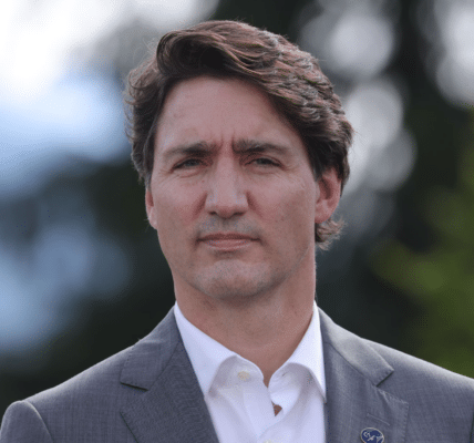 La imagen del ex primer ministro Justin Trudeau sobre un fondo borroso de árboles verdes.