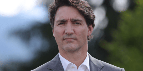 La imagen del ex primer ministro Justin Trudeau sobre un fondo borroso de árboles verdes.